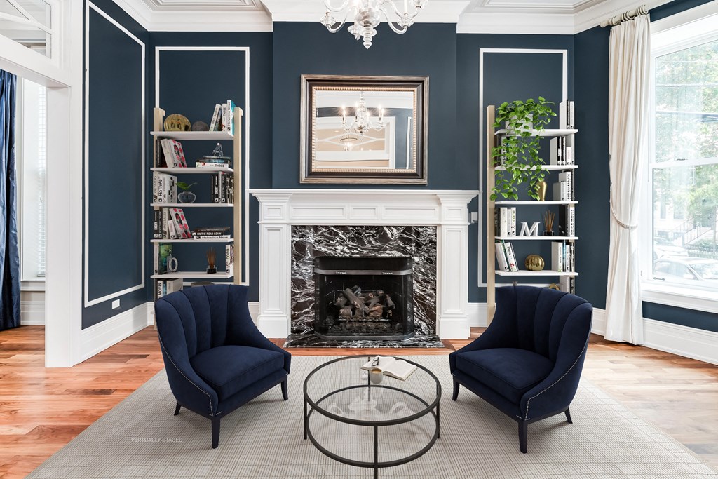a living room with two blue chairs and a fireplace