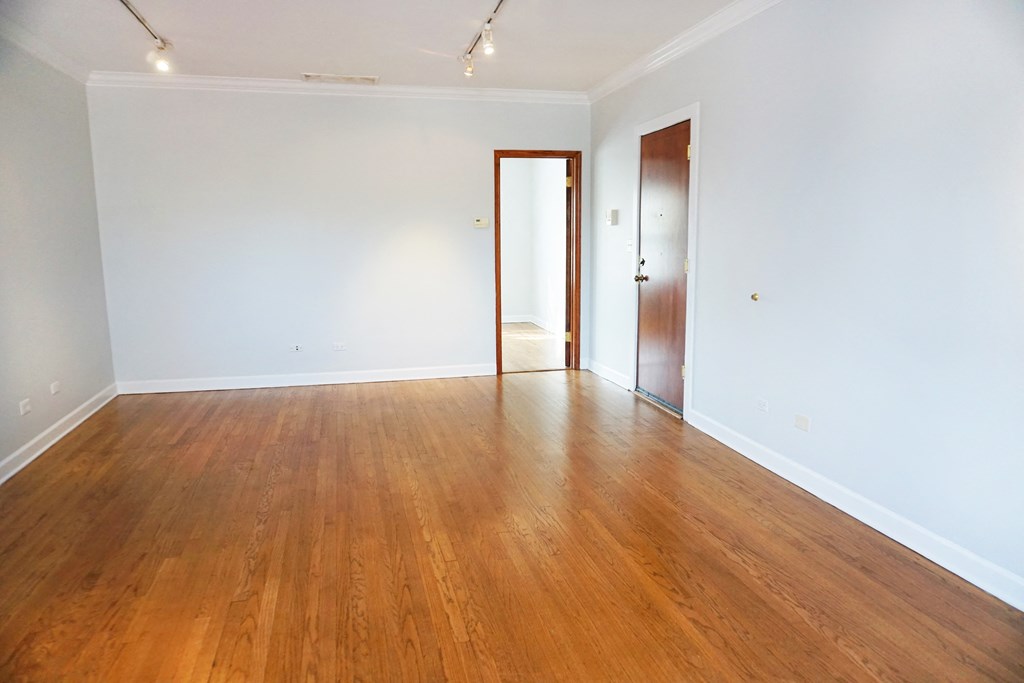 a empty living room with wood floors and white walls