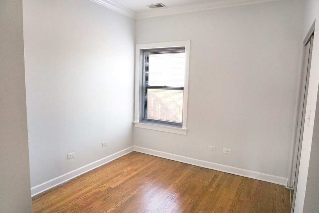 a bedroom with white walls and a window