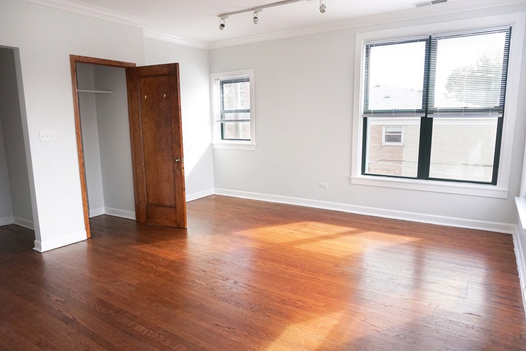 an empty living room with wood floors and a window