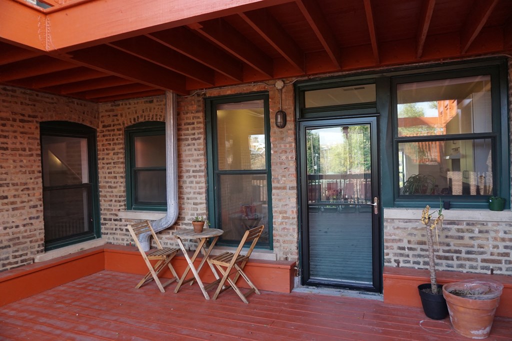 the front porch of a house with chairs and a table