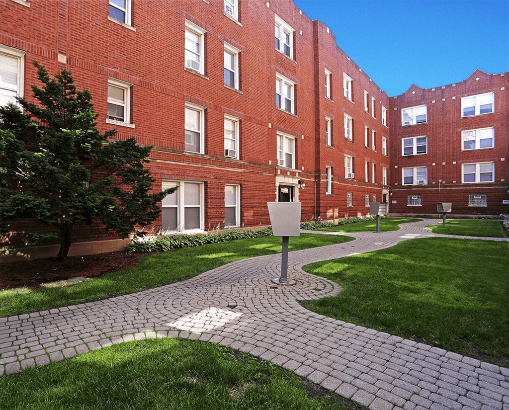 a walkway in front of a red brick building