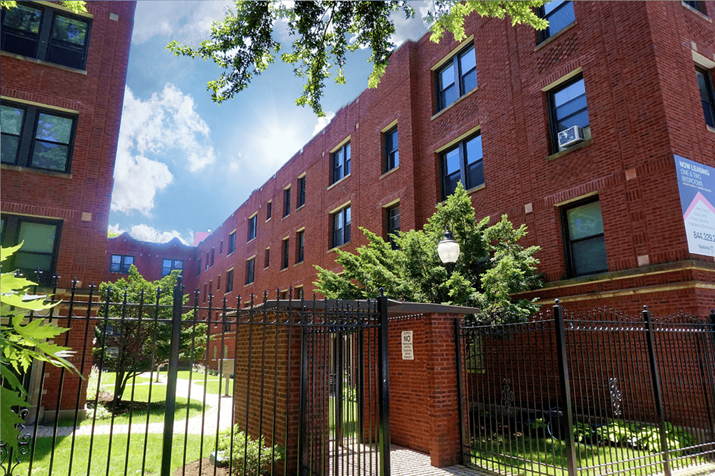 a red brick building with a black gate in front of it