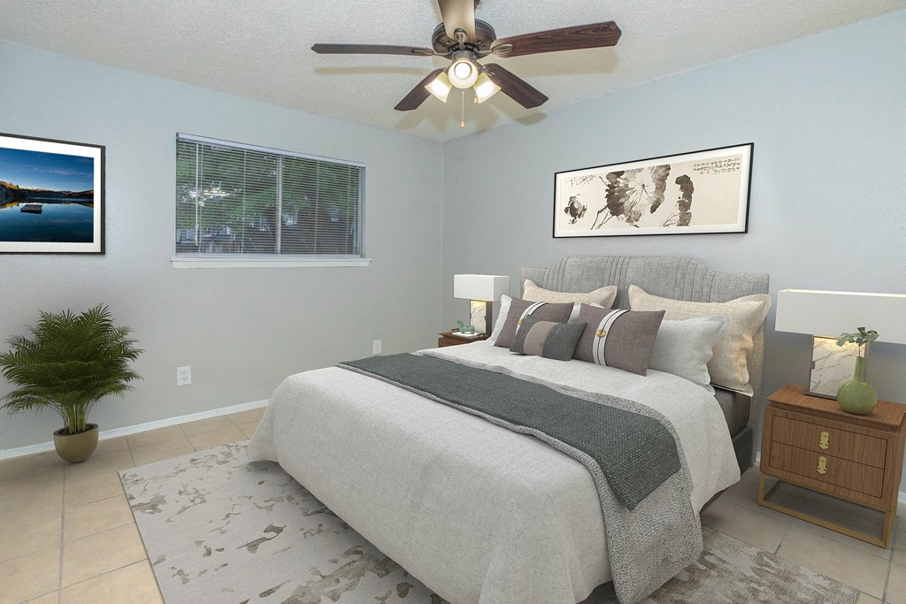 A bedroom with a large bed and a ceiling fan.