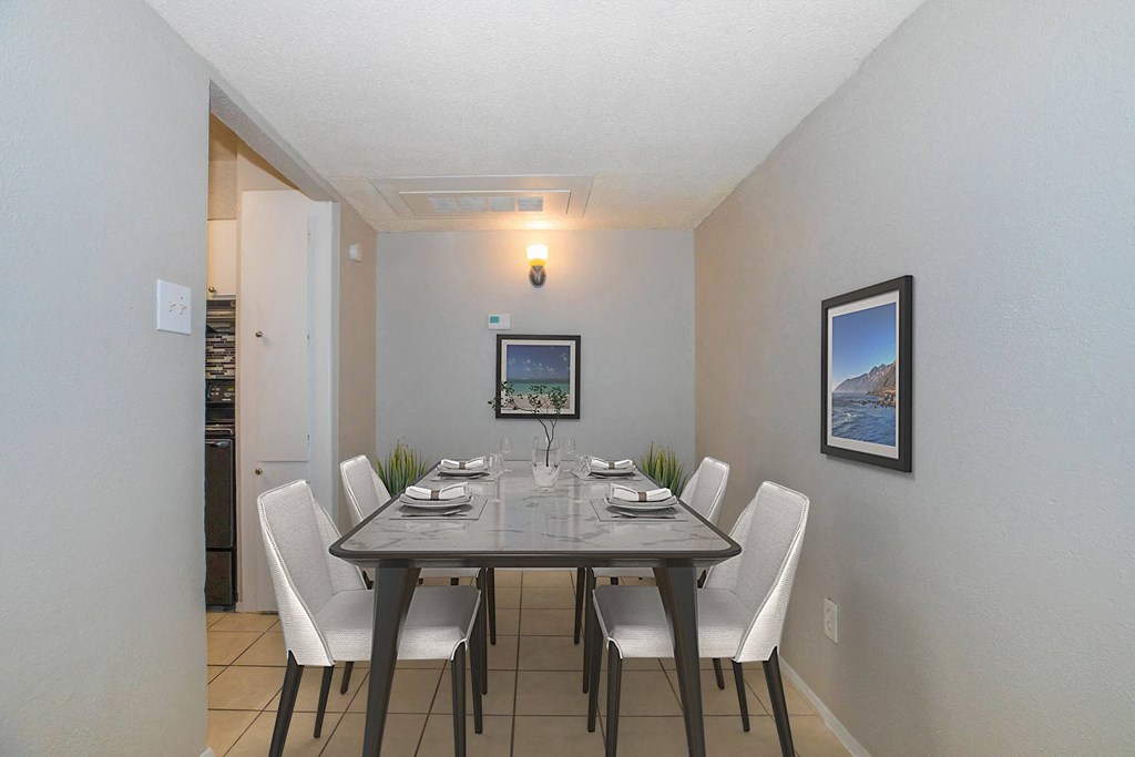A dining room with a table set for four.