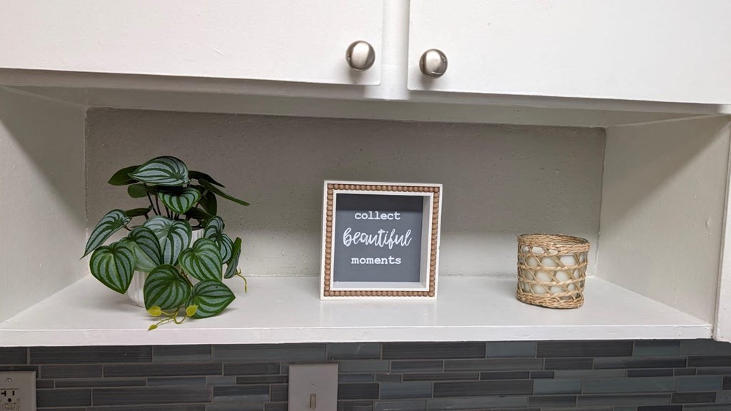 a shelf in a kitchen with a sign and a plant