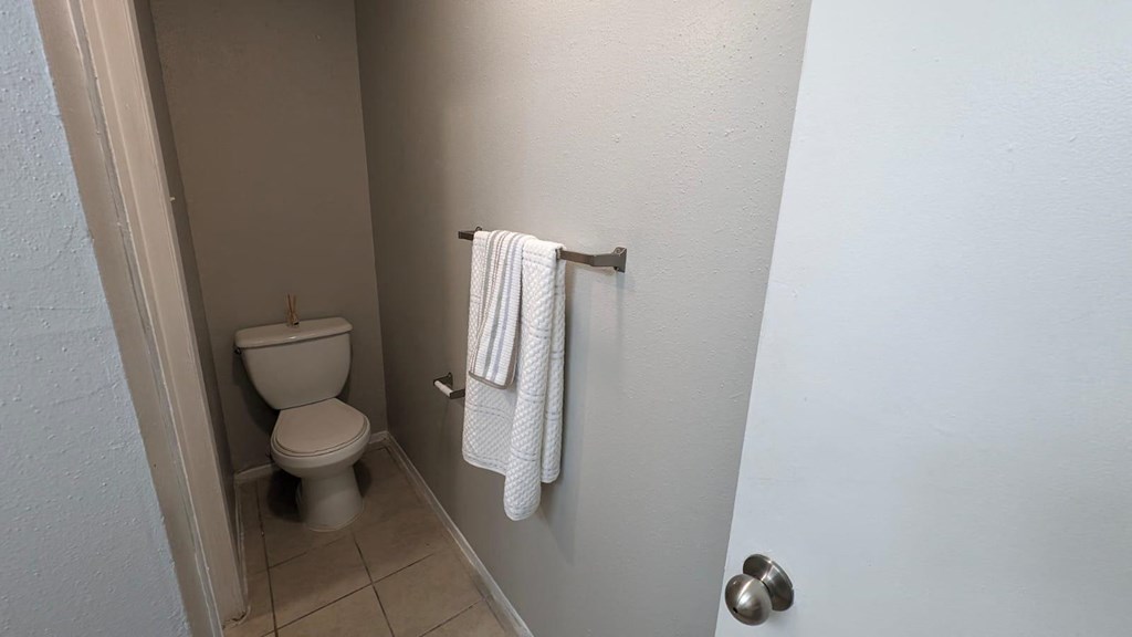 a bathroom with a toilet and a towel rack on the wall