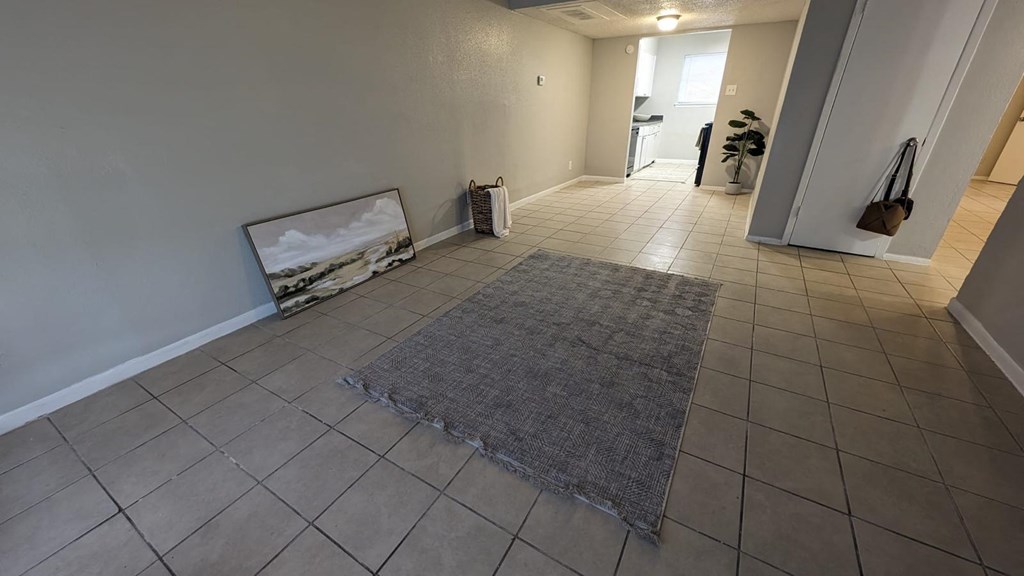 a living room with a rug on the tiled floor