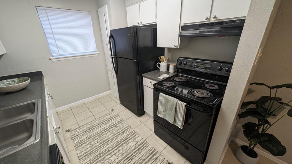 a kitchen with a stove refrigerator and a sink