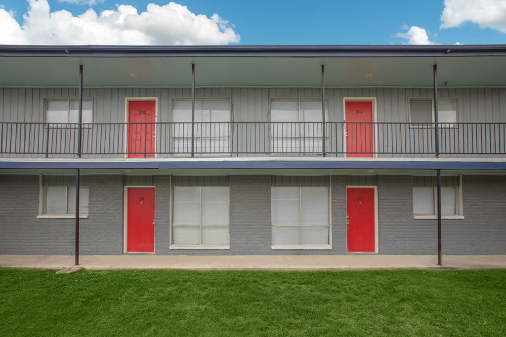 the front of a building with two red doors
