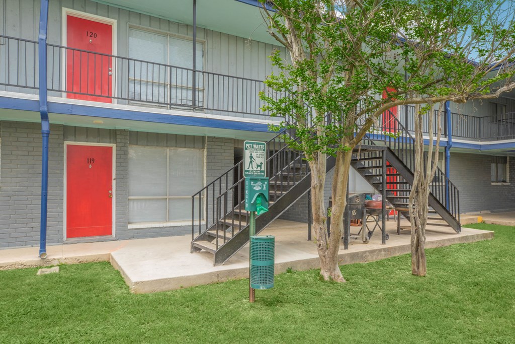 the front of a building with stairs and a red door