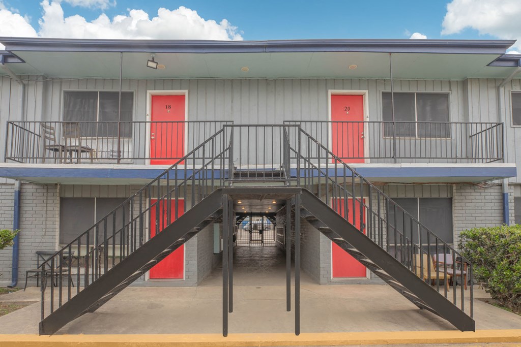 a staircase in front of a building with red doors