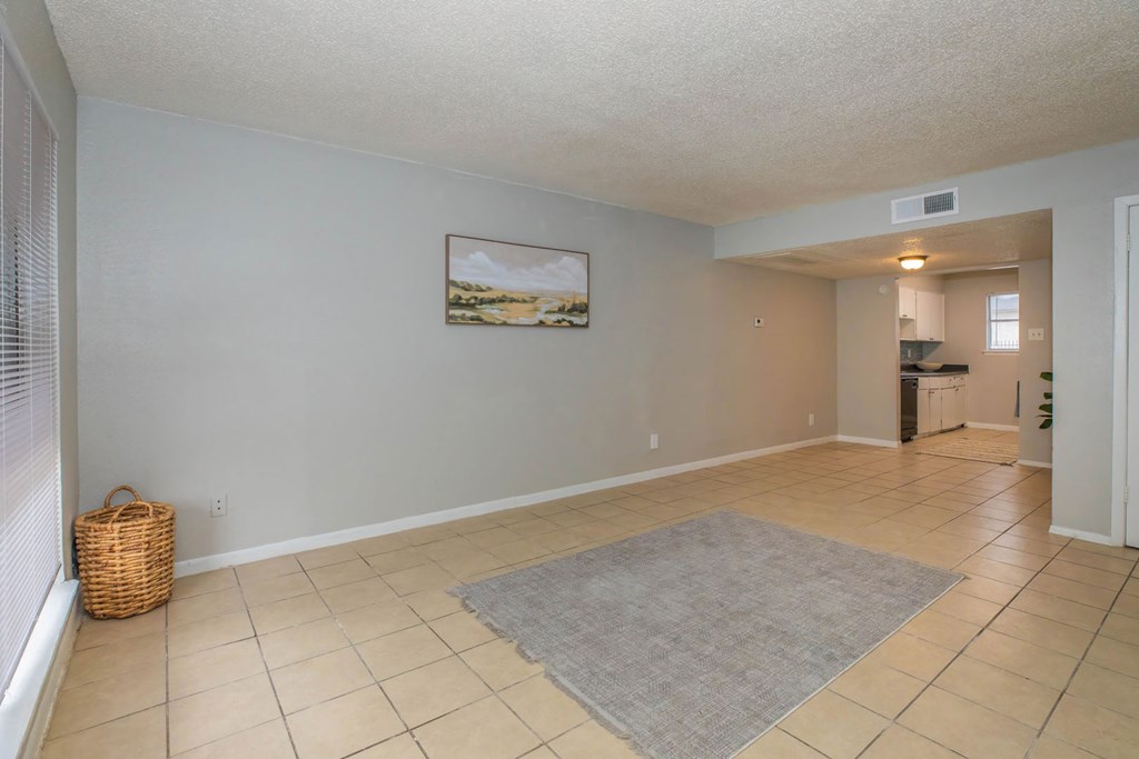 a living room with tile flooring and a rug