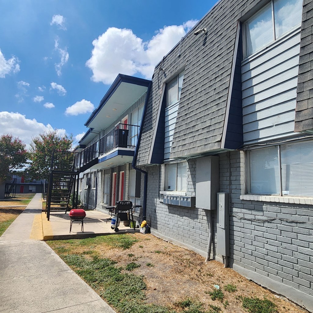 A grey building with a red chair in front of it.