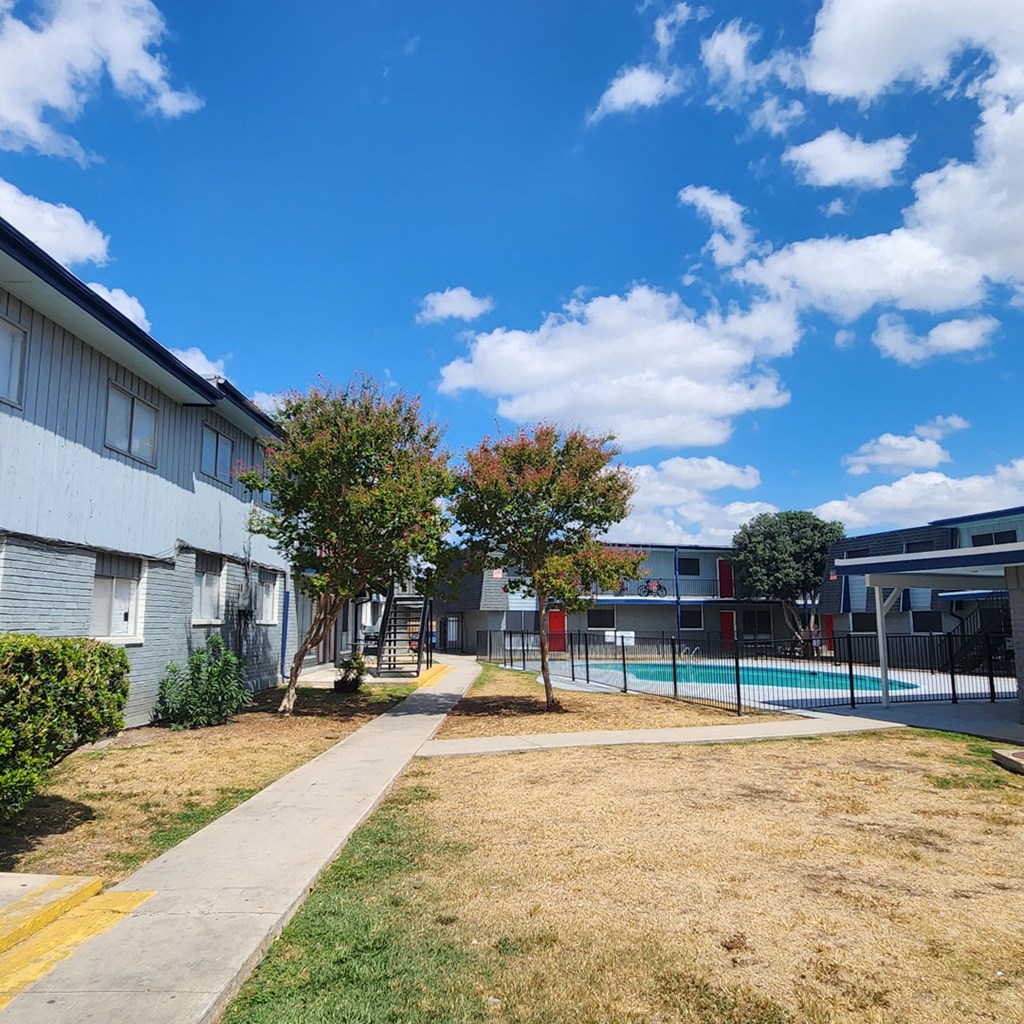 the courtyard of a building with a pool and trees
