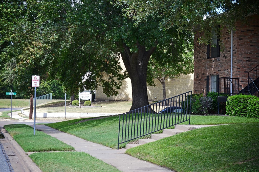 a wrought iron fence in front of a tree at Archer Village Apartments,Sherman, Texas, 75092
