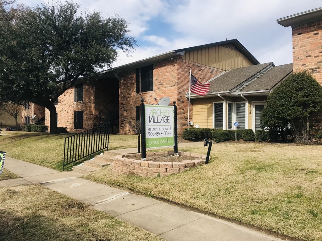 a house with an flag on the front of it at Archer Village Apartments, TX, 75092