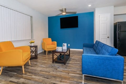 a living room with a blue couch and yellow chairs
