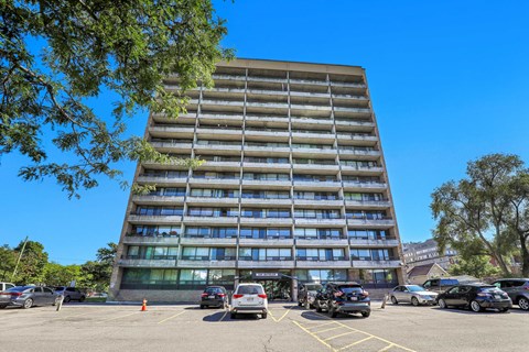A tall building with a parking lot in front of it.