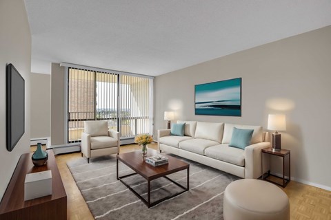 A living room with a white couch, a coffee table, and a painting on the wall.