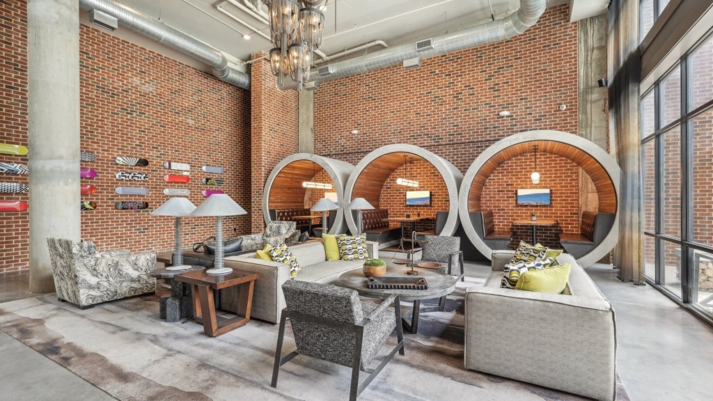 Resident clubhouse with many seating areas with couches, work booths, and chairs