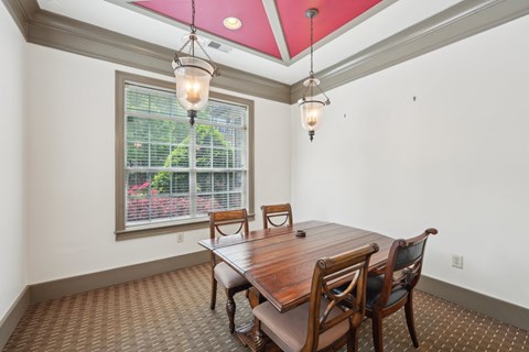 A dining room with a table and chairs.