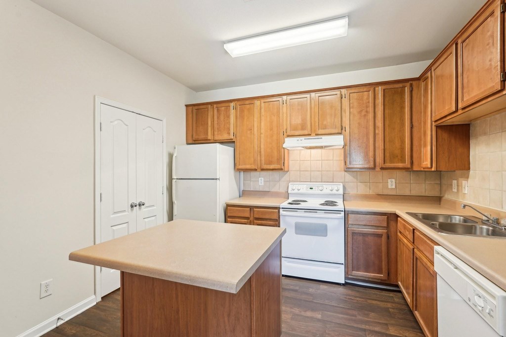A kitchen with wooden cabinets and white appliances.