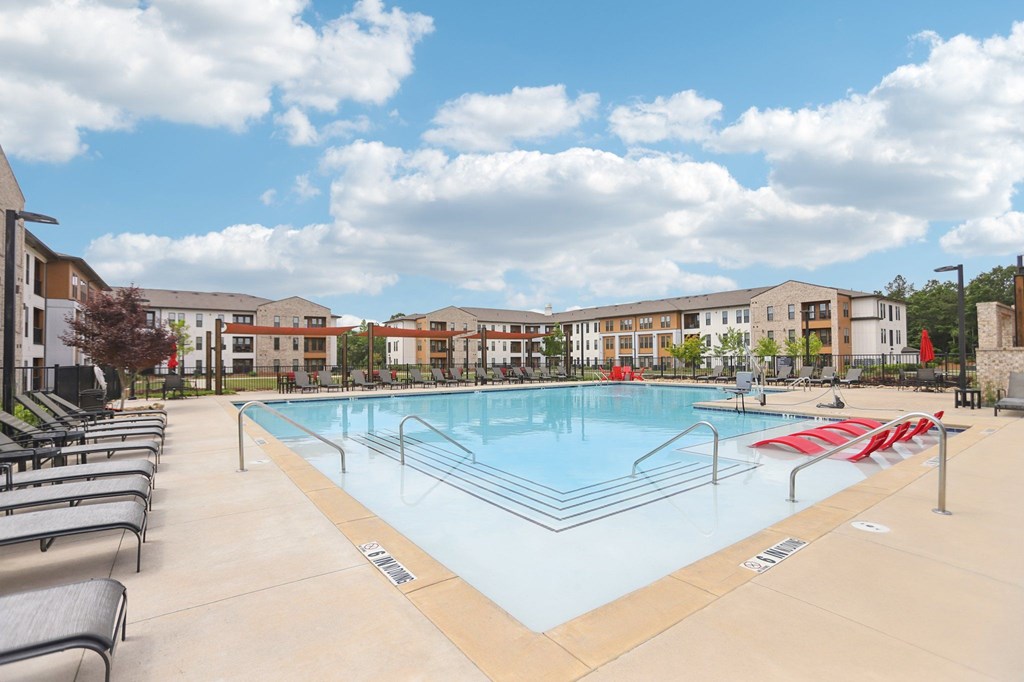 A large swimming pool with many lounge seats and areas