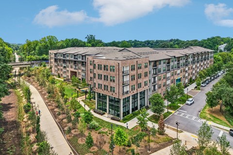 A large apartment complex with a walkway and trees.