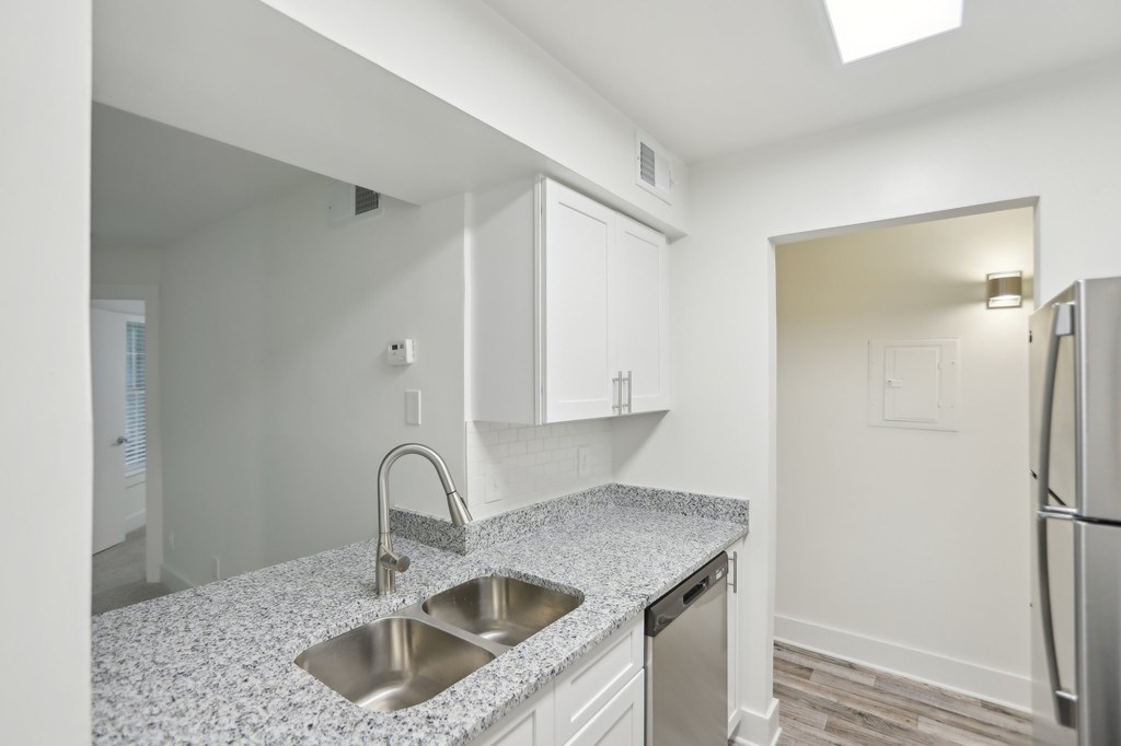 A kitchen with a granite countertop and stainless steel appliances.
