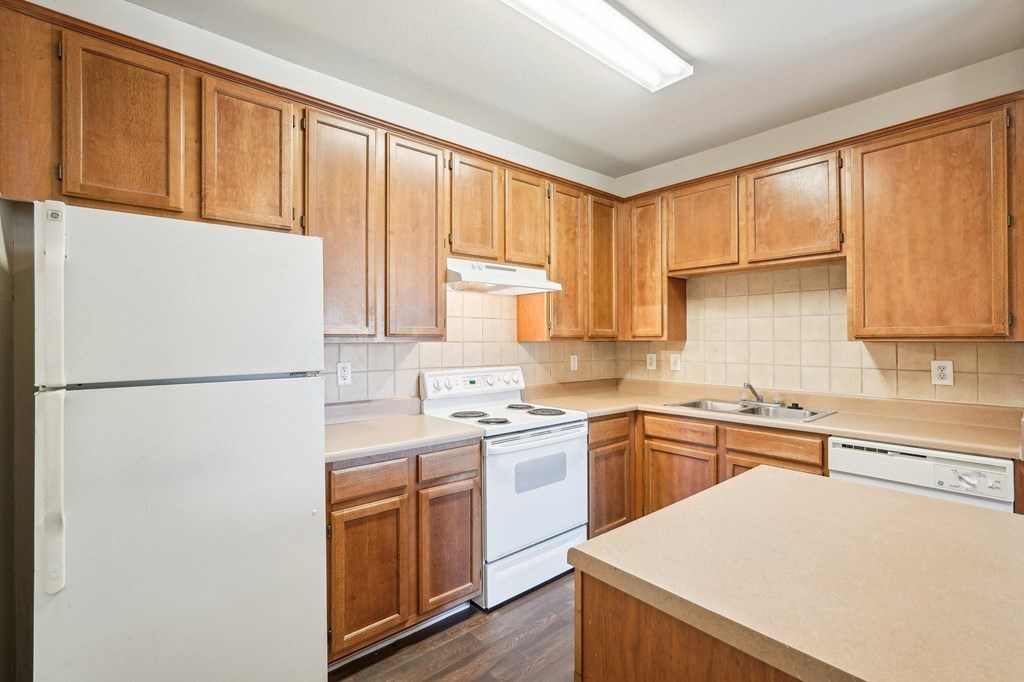 A kitchen with wooden cabinets and white appliances.