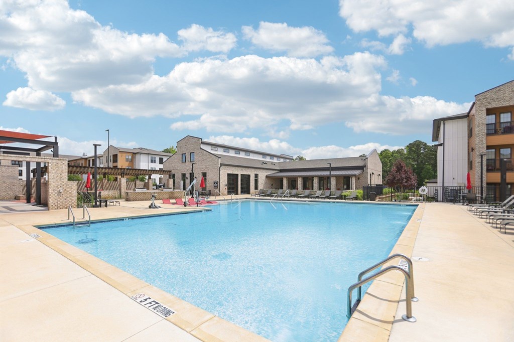 A large swimming pool with many lounge seats and areas