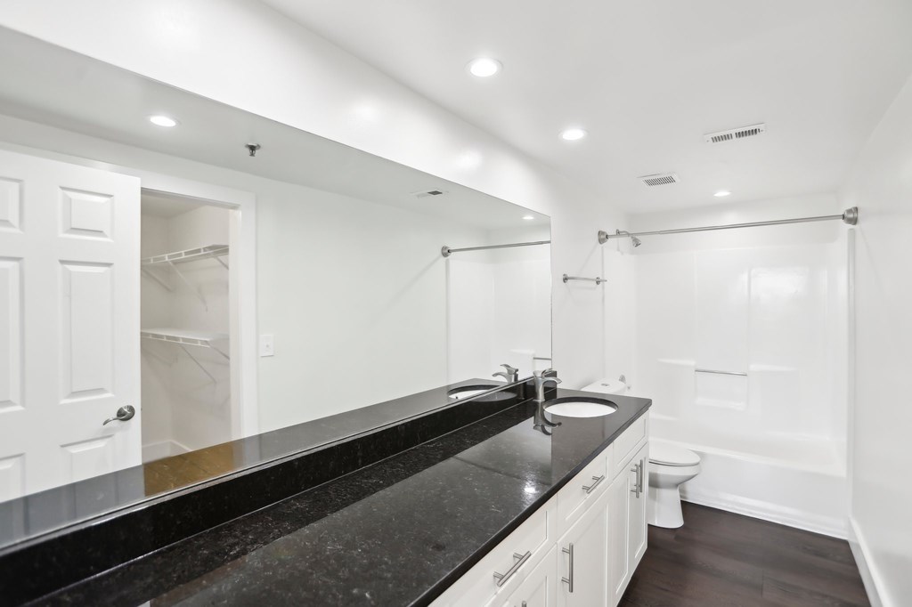 A bathroom with a black countertop and white walls.