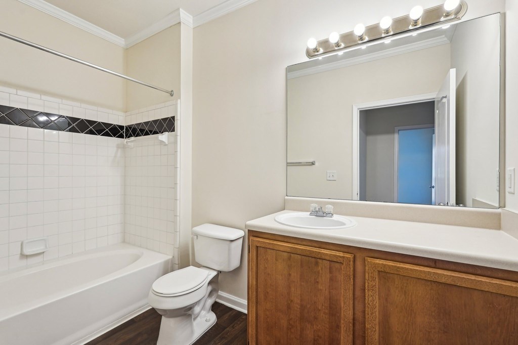 A bathroom with a white toilet, sink, and shower tub