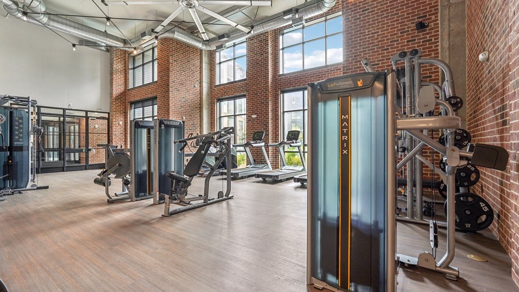 A gym with a variety of equipment including treadmills, weights, and exercise machines.