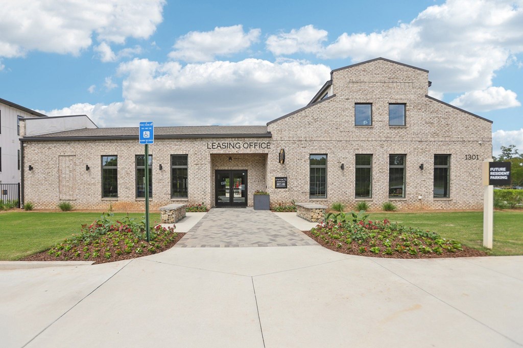 The leasing office and resident clubhouse  with a pool in the background.