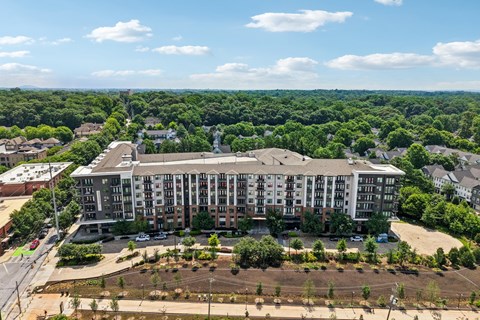A large apartment complex with a parking lot in front.