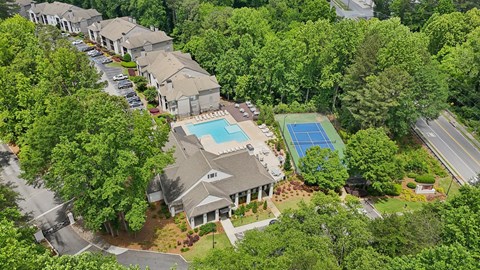 A bird's eye view of a residential area with houses and a swimming pool.