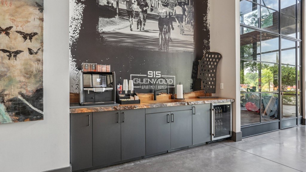 A wall mural in a room with a counter with a coffee machine, beverage fridge, and cabinets.