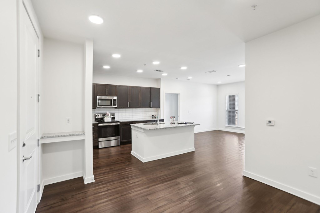 A kitchen with dark brown cabinets, stainless steel appliances and granite countertops