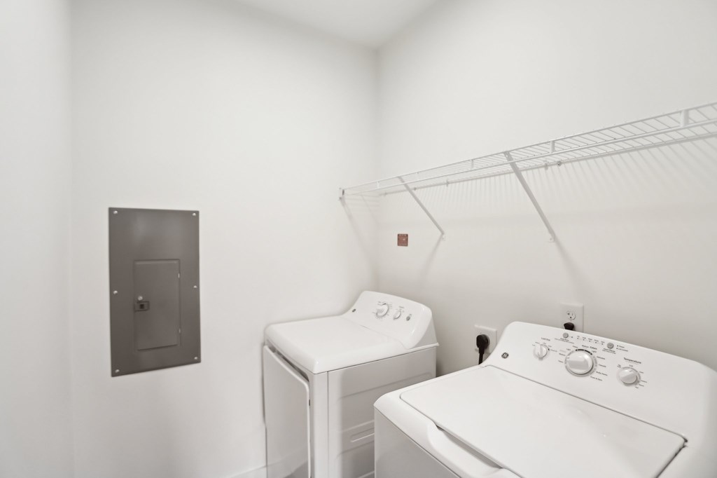 A white washing machine and dryer in a laundry room.