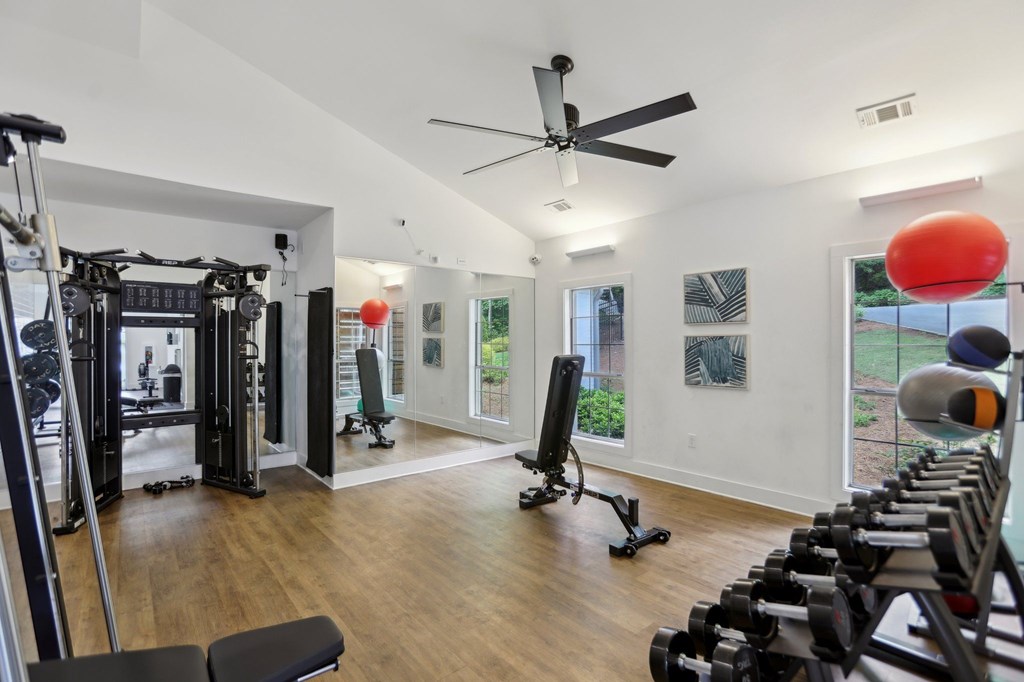 A gym with a variety of equipment including weights and a treadmill.