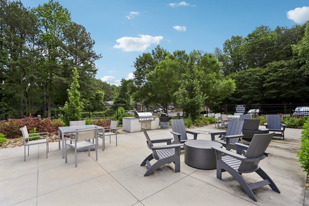 A patio with a table and chairs surrounded by trees.