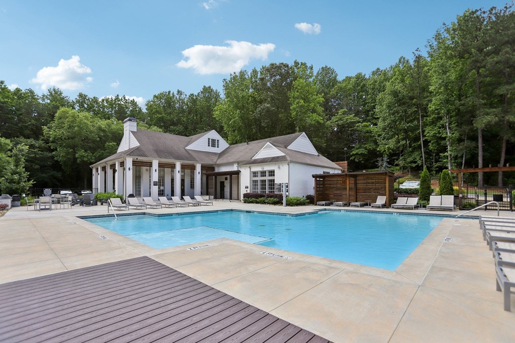 A pool with a cabana and many suntan and lounge chairs