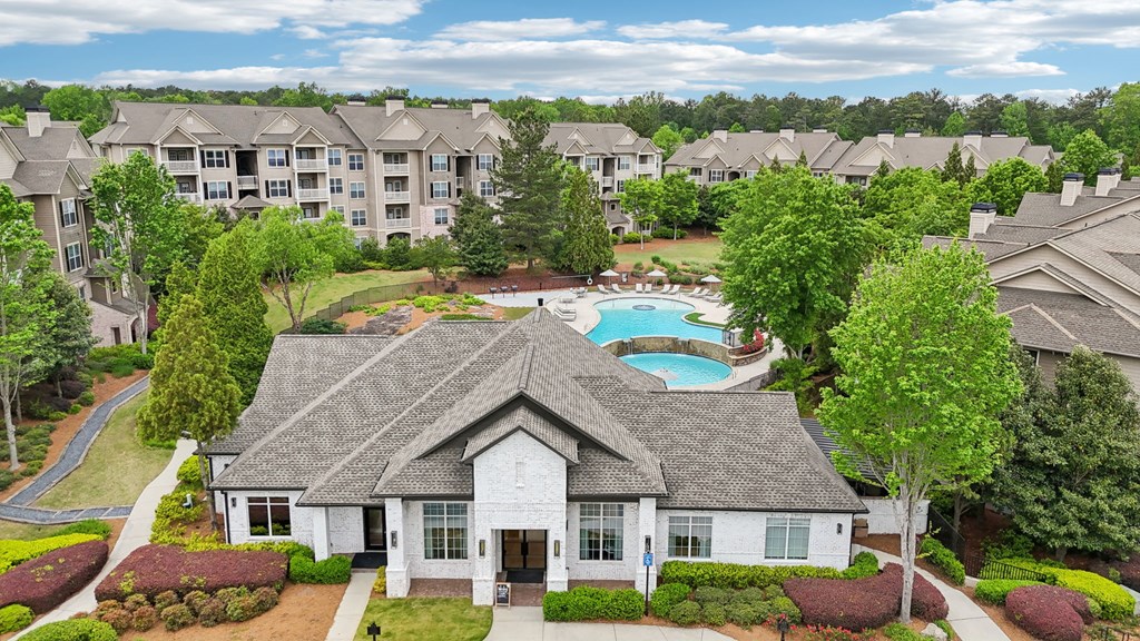 The leasing office and resident clubhouse  with a pool in the background.