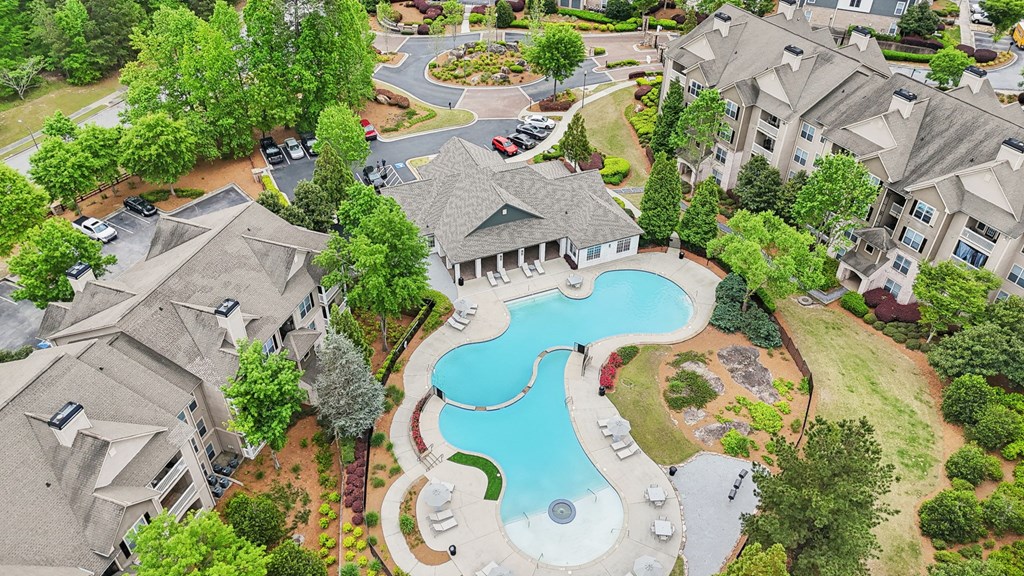 A bird's eye view of a residential area with apartments, and a swimming pool.