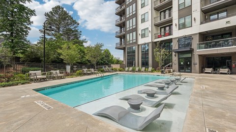 A large swimming pool in front of apartment buildings.
