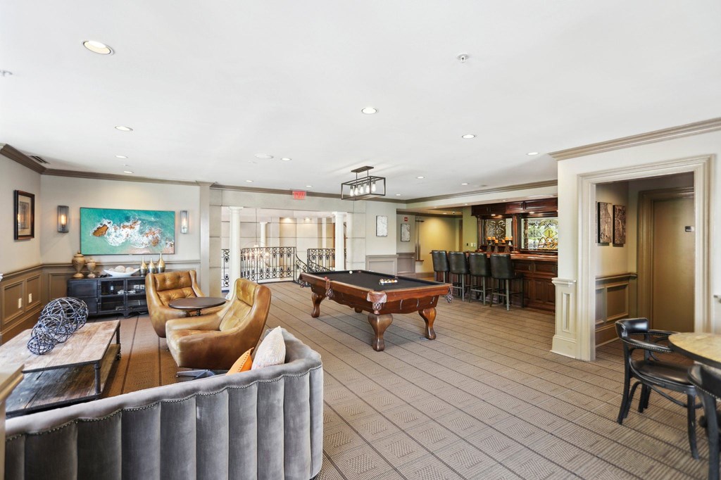 Resident Clubhouse: a large room with a pool table and comfortable seating at the bar with a coffee machine
