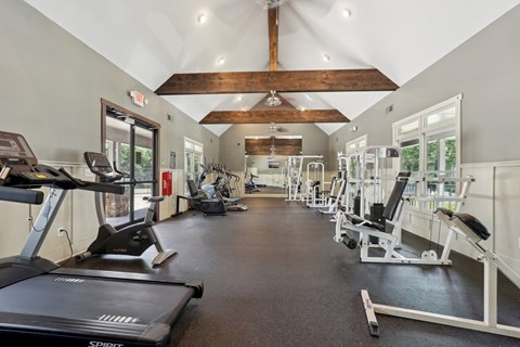 A gym with treadmills, weights, and exercise equipment.