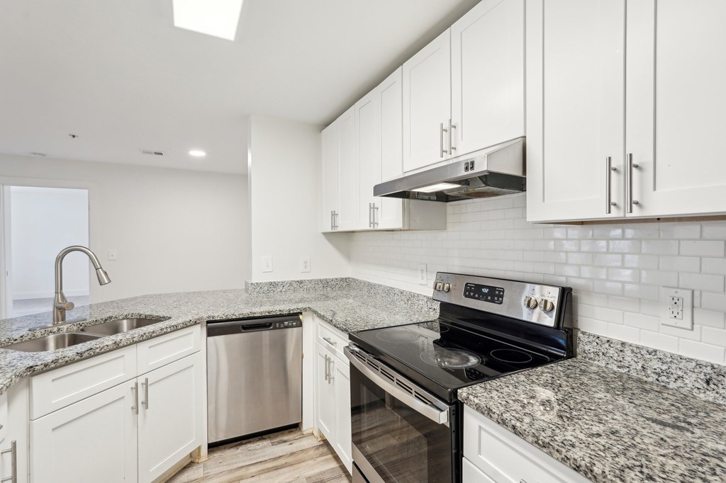 A modern kitchen with granite countertops and stainless steel appliances.